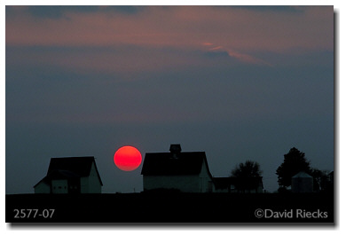 Three barns under setting sun