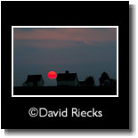 Three barns under setting sun